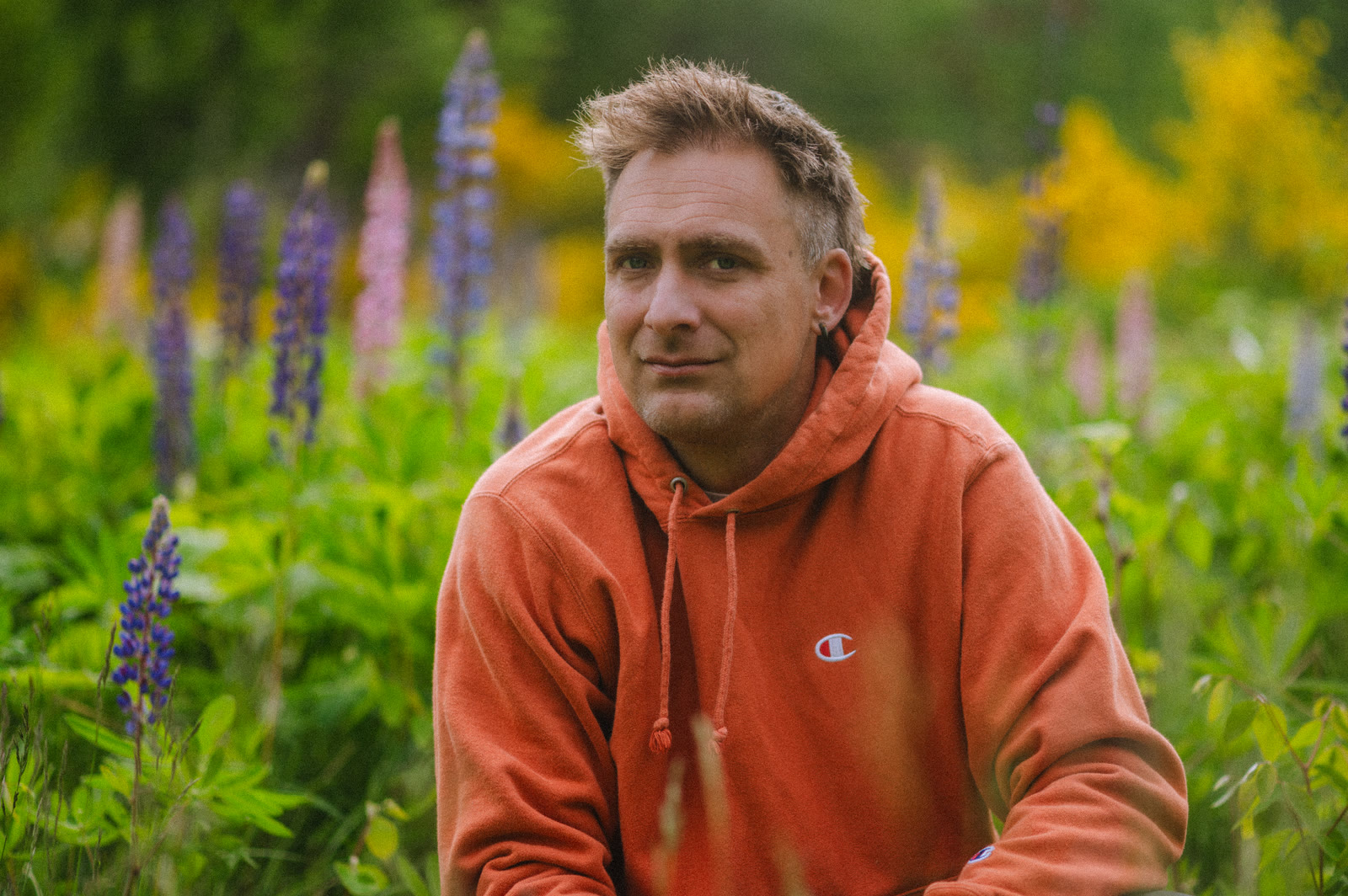 Roy Gregory Clayton outdoors among lupines in the Kootenays